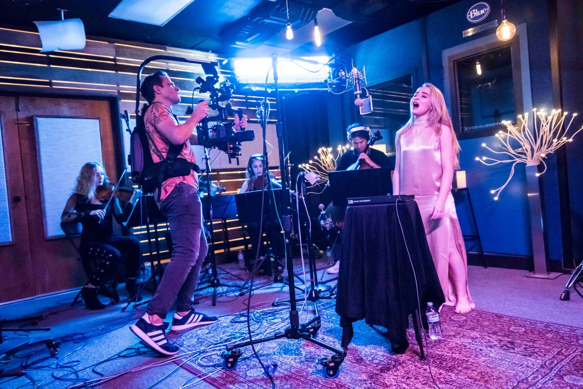 Kerry Henderson operating a camera rig during a recording-studio performance.
