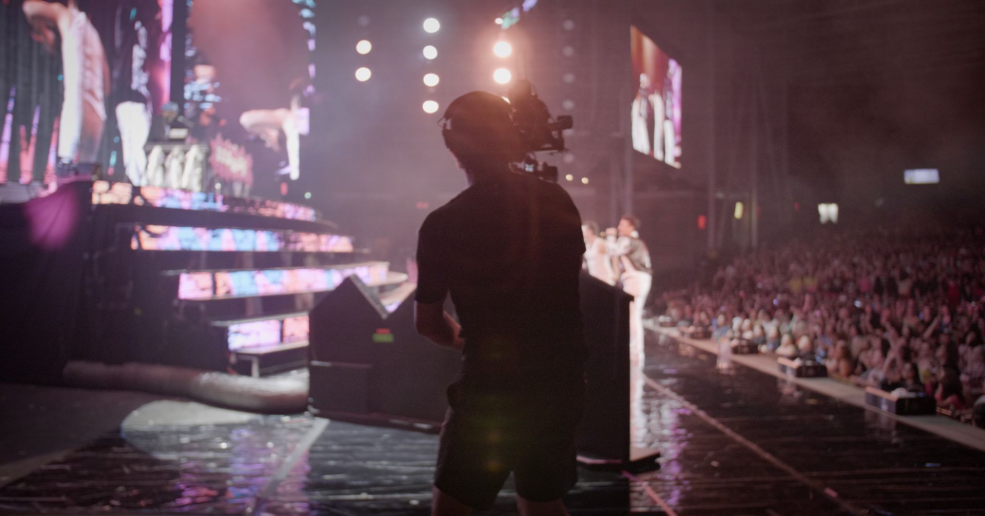 A Stage Left Creative camera operator filming a live concert from the stage.