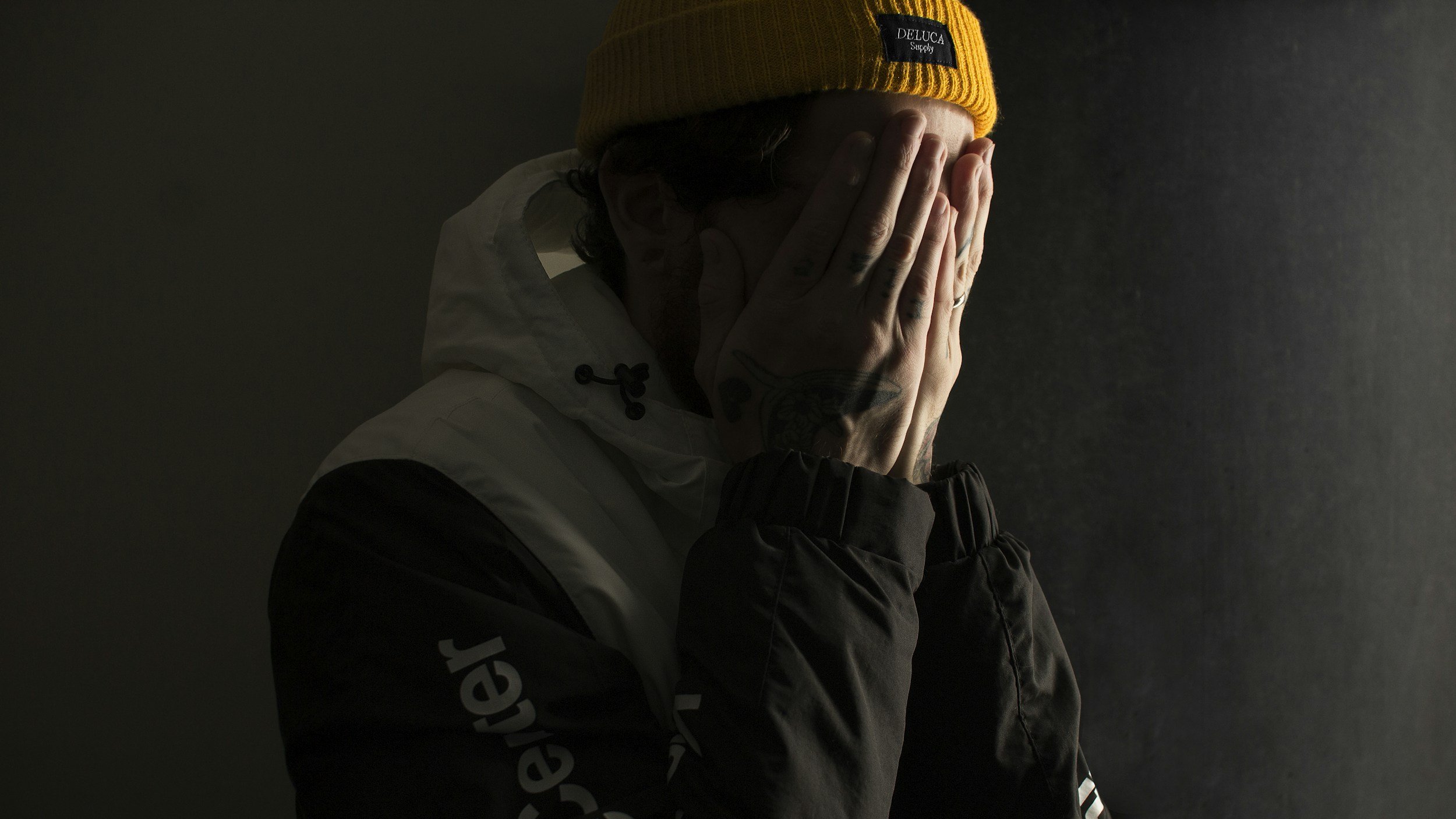 man covering his face with his hands