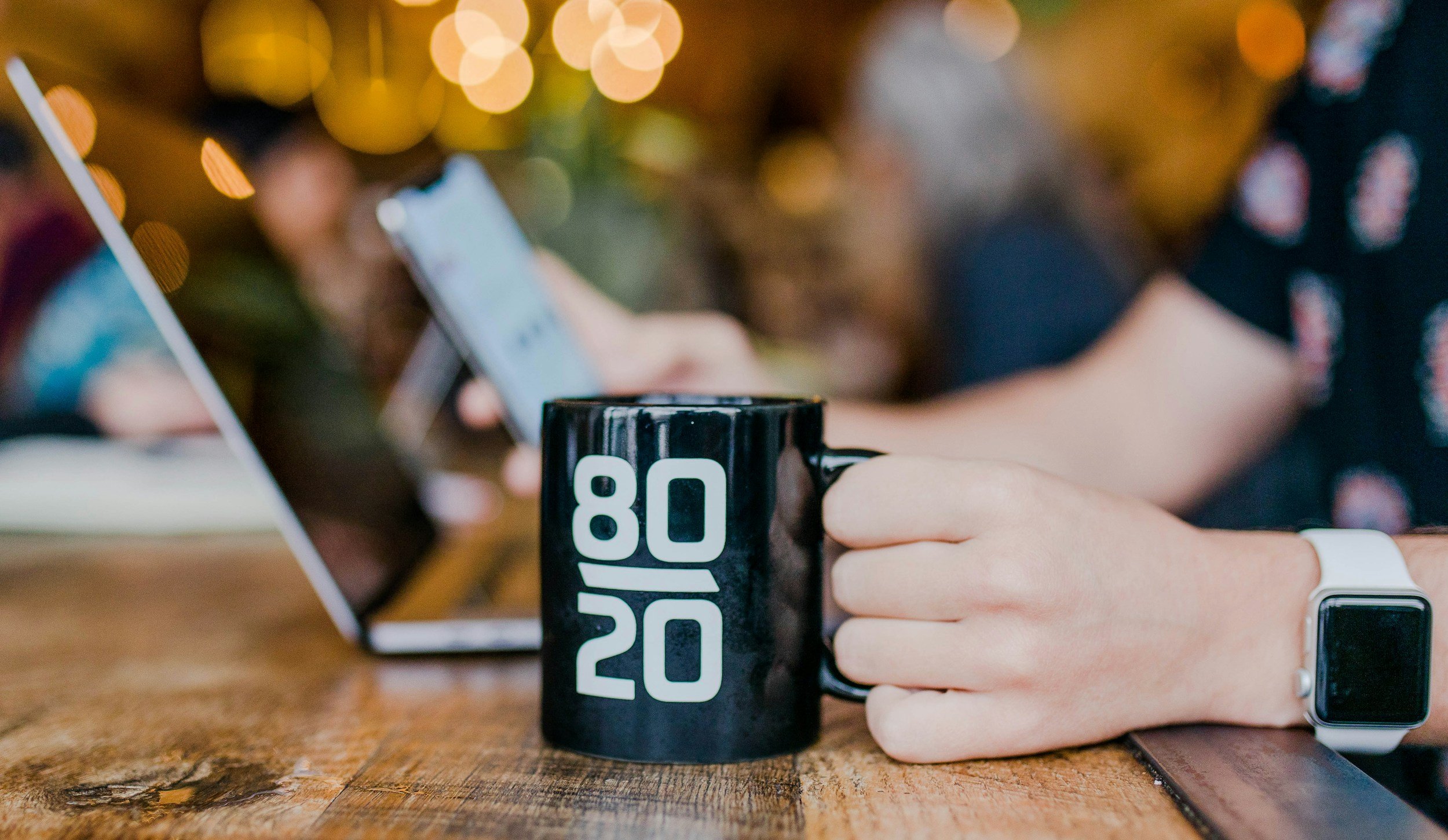 hand holding a mug at a table